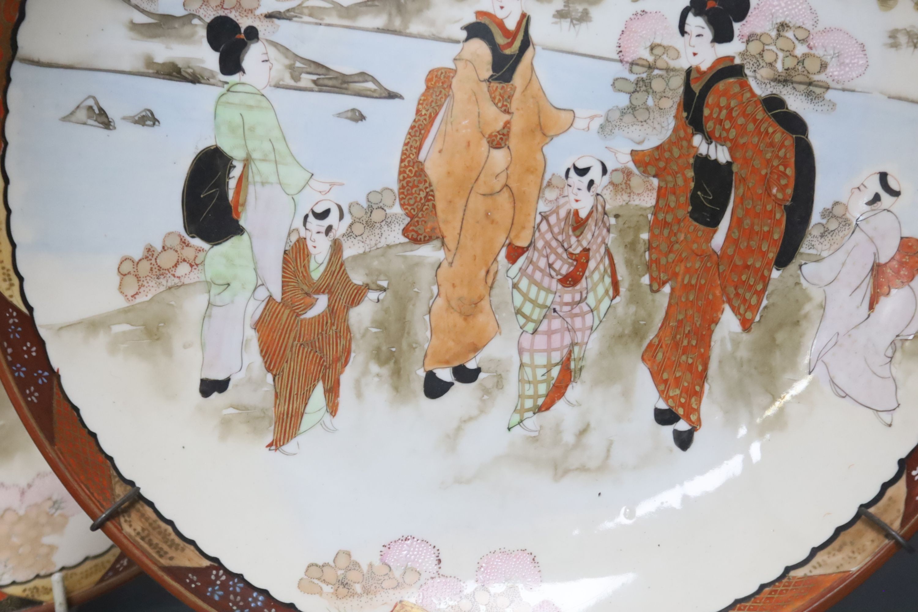 A late 19th century Japanese porcelain oval dish, 29cm, and a pair of Kutani style wall plates, 30cm